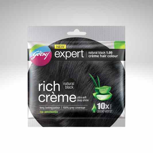 Godrej Expert Rich Creme hair colour in natural black, 100% grey coverage, no ammonia, in a clear plastic pouch with a black hair-color circle graphic and green aloe vera illustration.