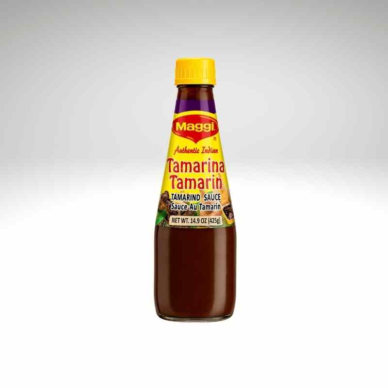 A bottle of Maggi Authentic Tamarind Sauce, featuring a yellow cap and a yellow label with red and black text, set against a light gray gradient background.