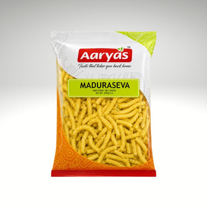 A bag of Aaryas Maduraseva fried chips on a light gray gradient background. The packaging features a white top section with the red Aaryas logo, a bright green label with the product name, and an orange patterned bottom section showing the yellow chips through a clear window.