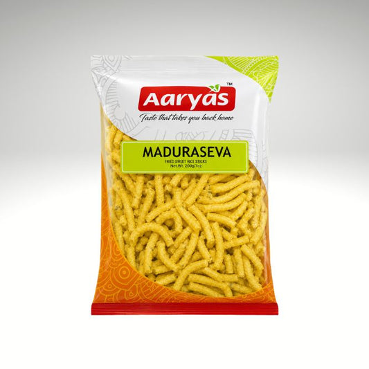A bag of Aaryas Maduraseva fried chips on a light gray gradient background. The packaging features a white top section with the red Aaryas logo, a bright green label with the product name, and an orange patterned bottom section showing the yellow chips through a clear window.