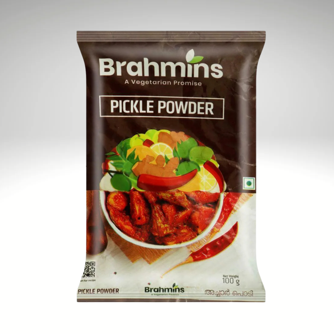 A packet of Brahmins Pickle Powder, featuring vibrant packaging, placed next to a small bowl filled with the flavorful spice mix, emphasizing its aromatic ingredients for making homemade pickles.