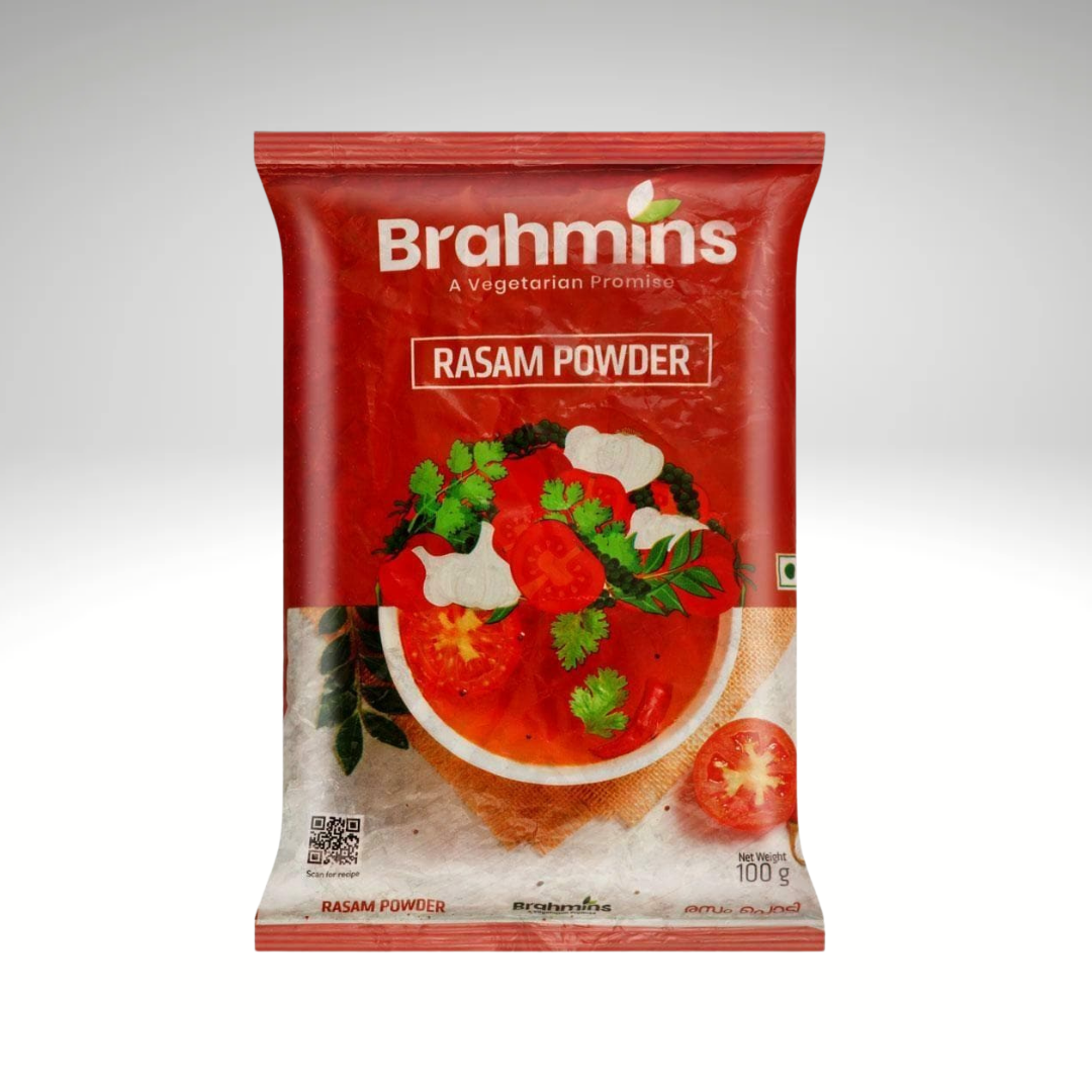 A packet of Brahmins Rasam Powder Mix, featuring vibrant packaging, placed next to a bowl of steaming rasam garnished with fresh coriander, showcasing its aromatic spices and traditional South Indian taste.