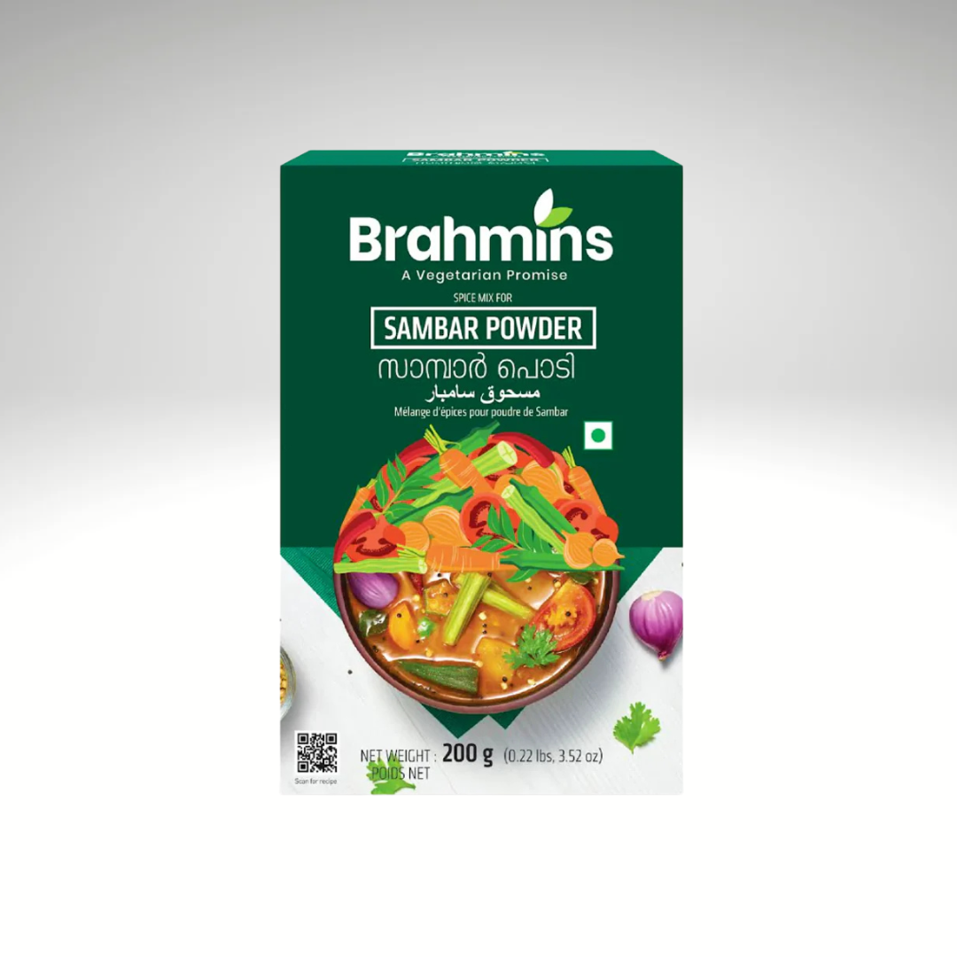 A packet of Brahmins Sambar Powder Mix, with colorful packaging, displayed alongside a bowl of steaming sambar filled with vegetables, highlighting its aromatic spices and traditional South Indian flavours.