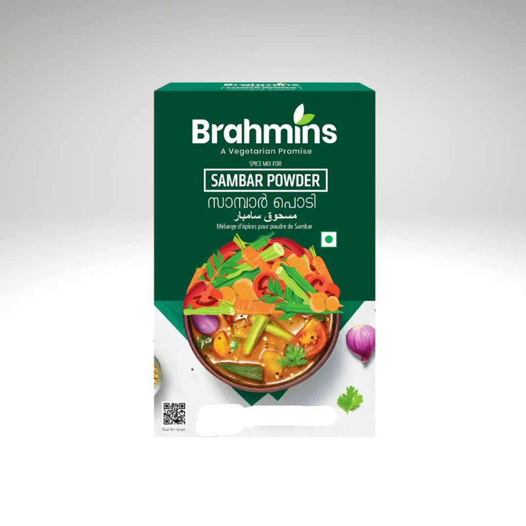 A packet of Brahmins Sambar Powder Mix, with colorful packaging, displayed alongside a bowl of steaming sambar filled with vegetables, highlighting its aromatic spices and traditional South Indian flavours.