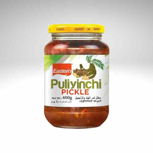 A glass jar of Eastern brand Puliyinchi Pickle with a yellow lid and a white label featuring green and red text, set against a light gray gradient background.