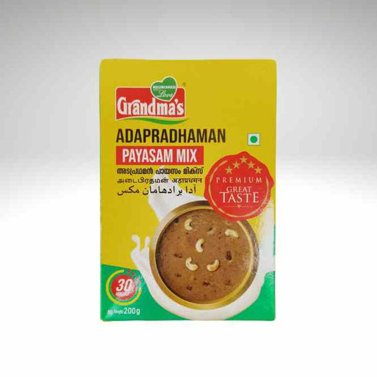 A 200g package of Grandma's Payasam Mix (Adapradhaman) on a light gray gradient background. The packaging is primarily yellow with green and red accents, featuring a photo of the prepared brown payasam with cashews.