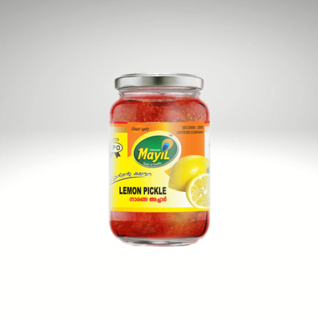 Mayil Lime Pickle, a jar of traditional South Indian-style pickle made from fresh lime pieces, preserved with spices and oil. The product is packaged in a green and yellow jar, displaying the Mayil brand logo, with a label detailing the ingredients and adding a tangy, spicy kick to dishes.