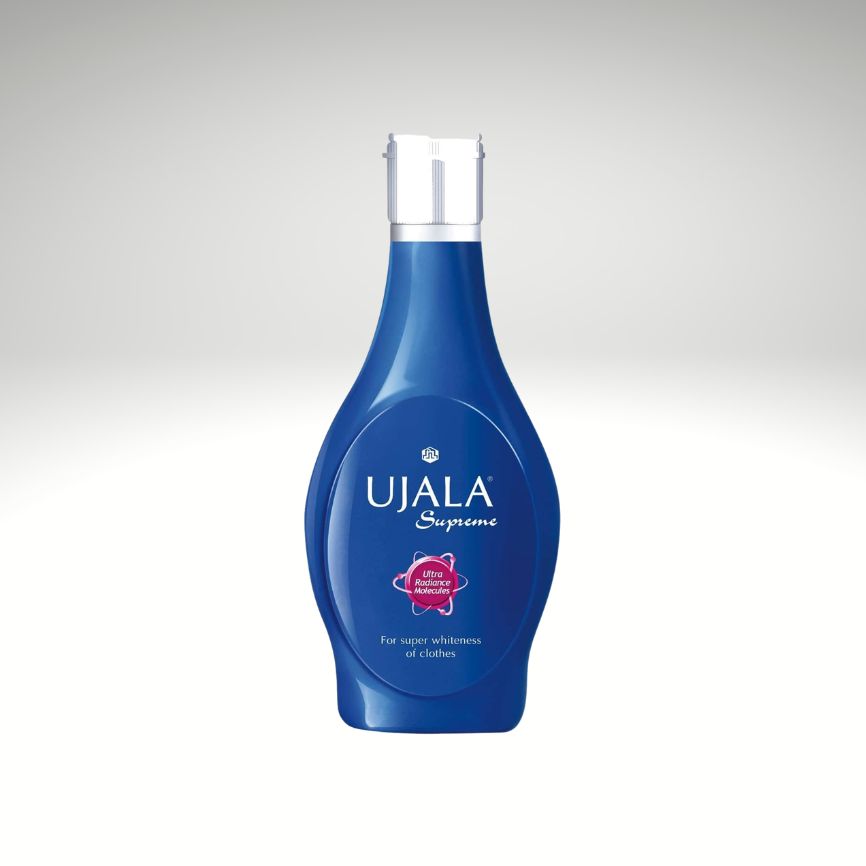 A blue plastic bottle of Ujala Supreme Ayurvedic medicine for constipation, featuring a white cap and a white label with blue text, set against a light gray gradient background.